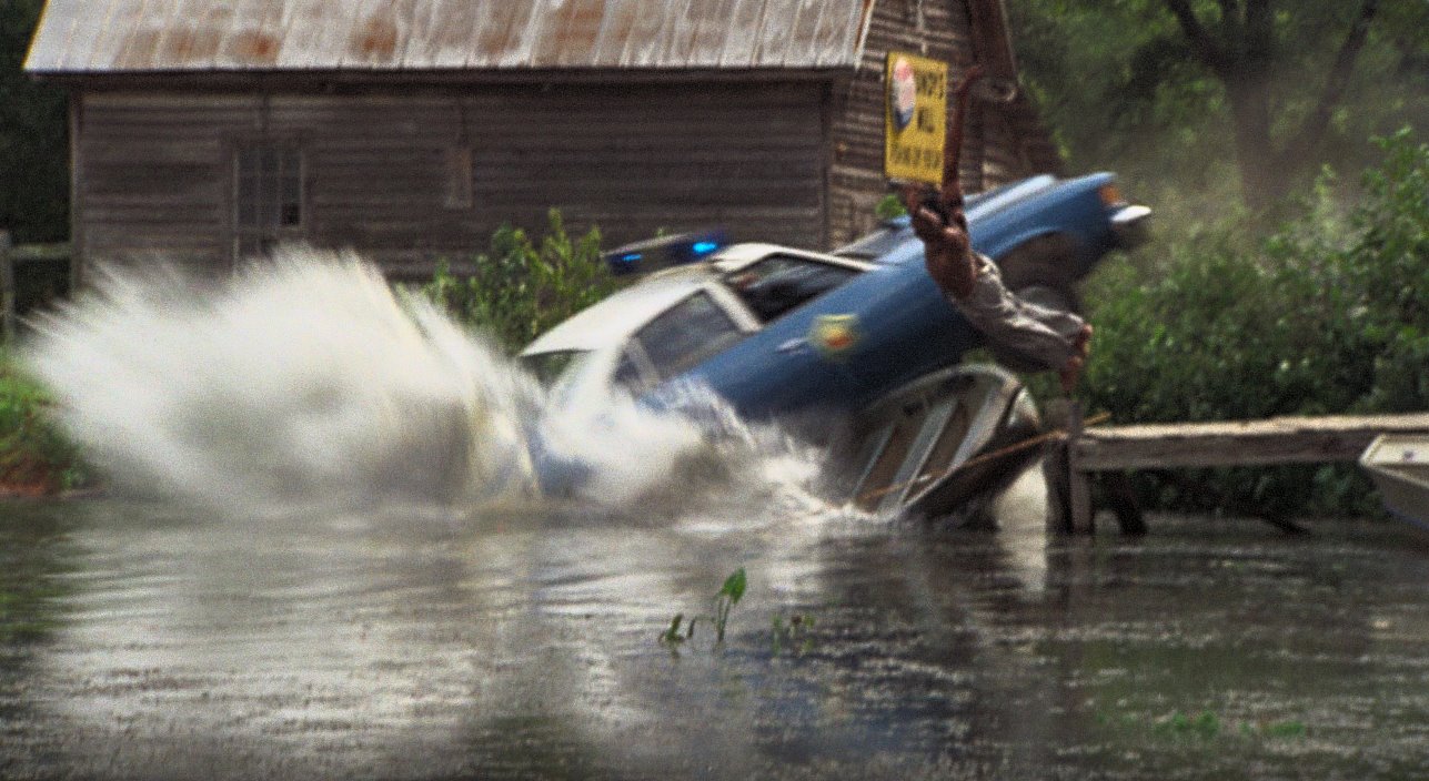 On Day 5 of filming, September 3, 1976, we film our first major stunt; the Arkansas Highway Patrol crashing into the pond.